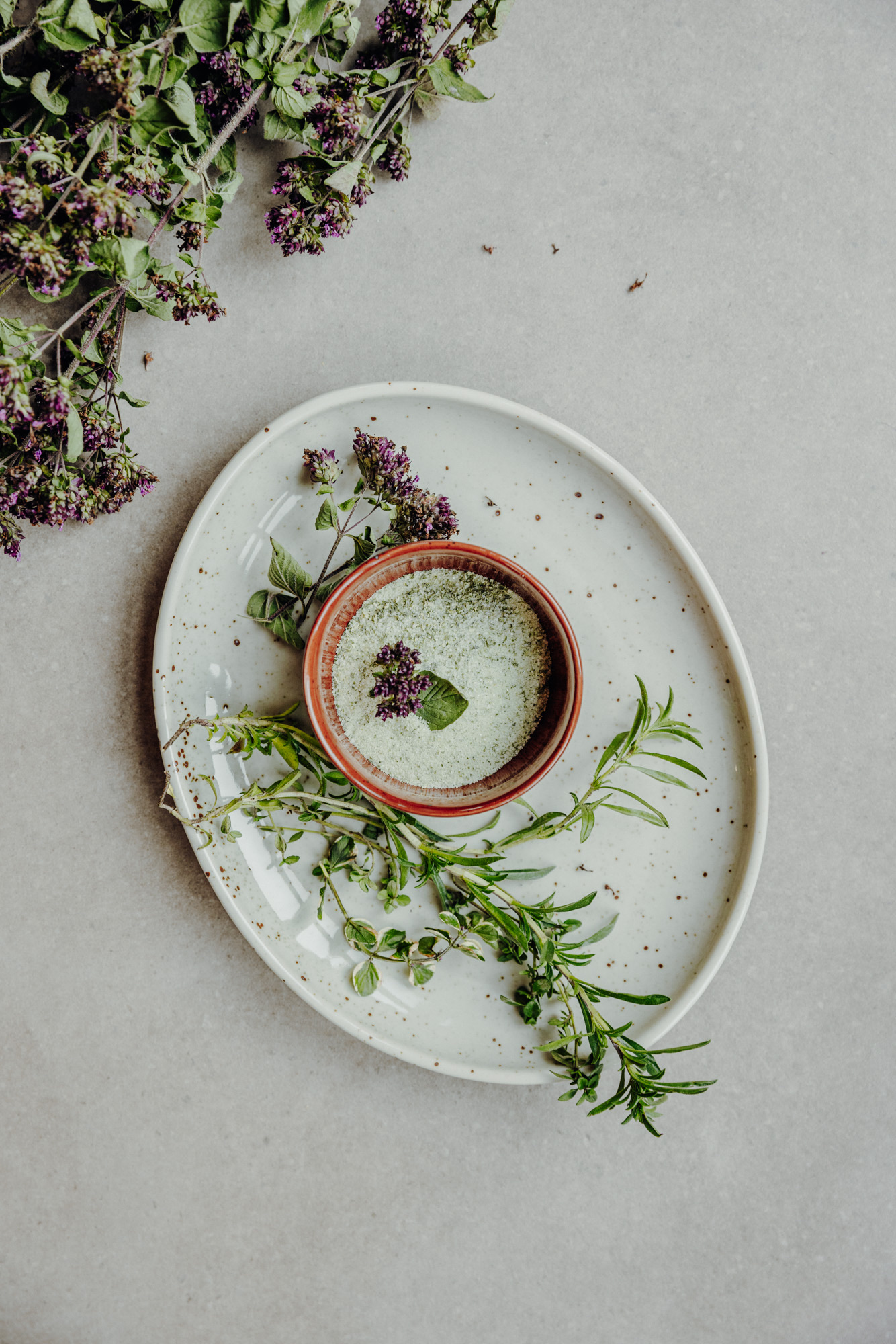 Plate with fresh herbs and a small bowl of olive oil