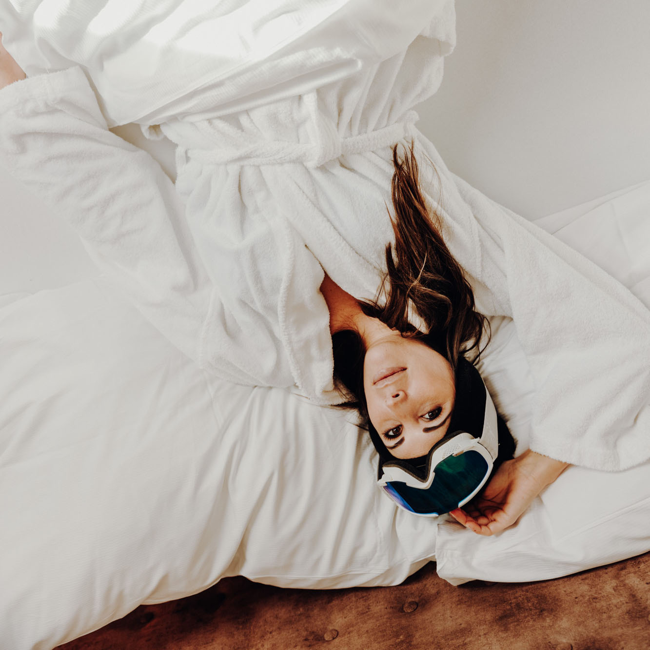 Woman with a sleep mask lying in white bedding